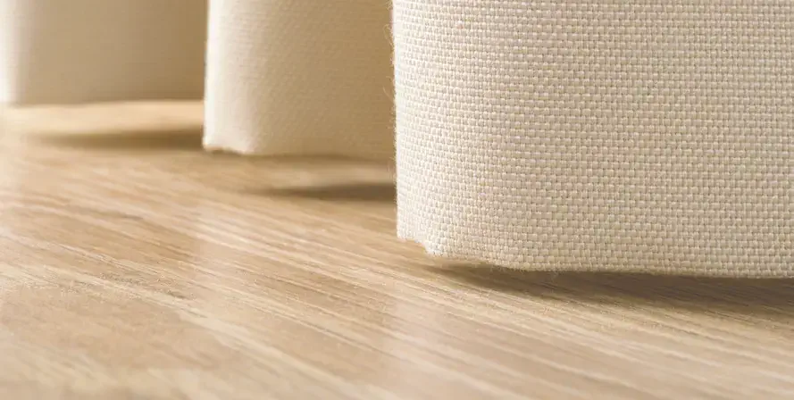 Tette eller tunge tekstiler sys med blindstingsøm som skjuler trådene for et sømløst uttrykk. Standard er 7 cm bunnsøm som støtter opp vekten og gir et pent fall. For ullfilt kan man også velge rå, skarp kant uten søm for et minimalistisk uttrykk.